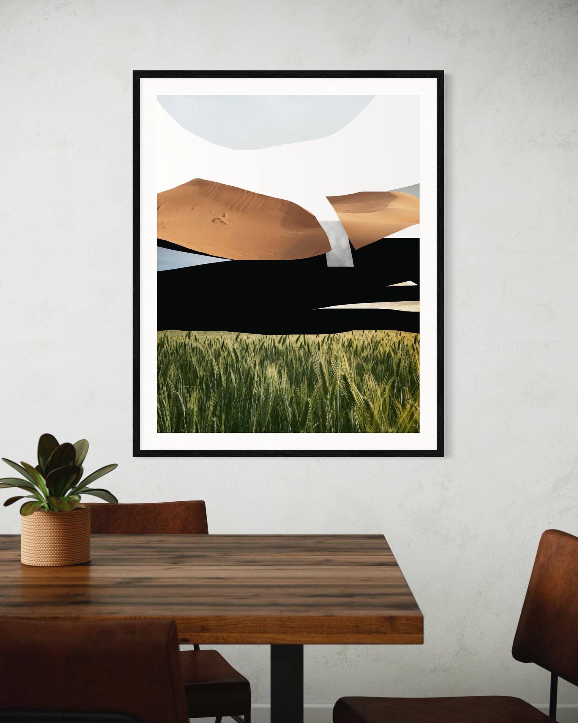 Framed abstract artwork on a wall above a wooden table with chairs.