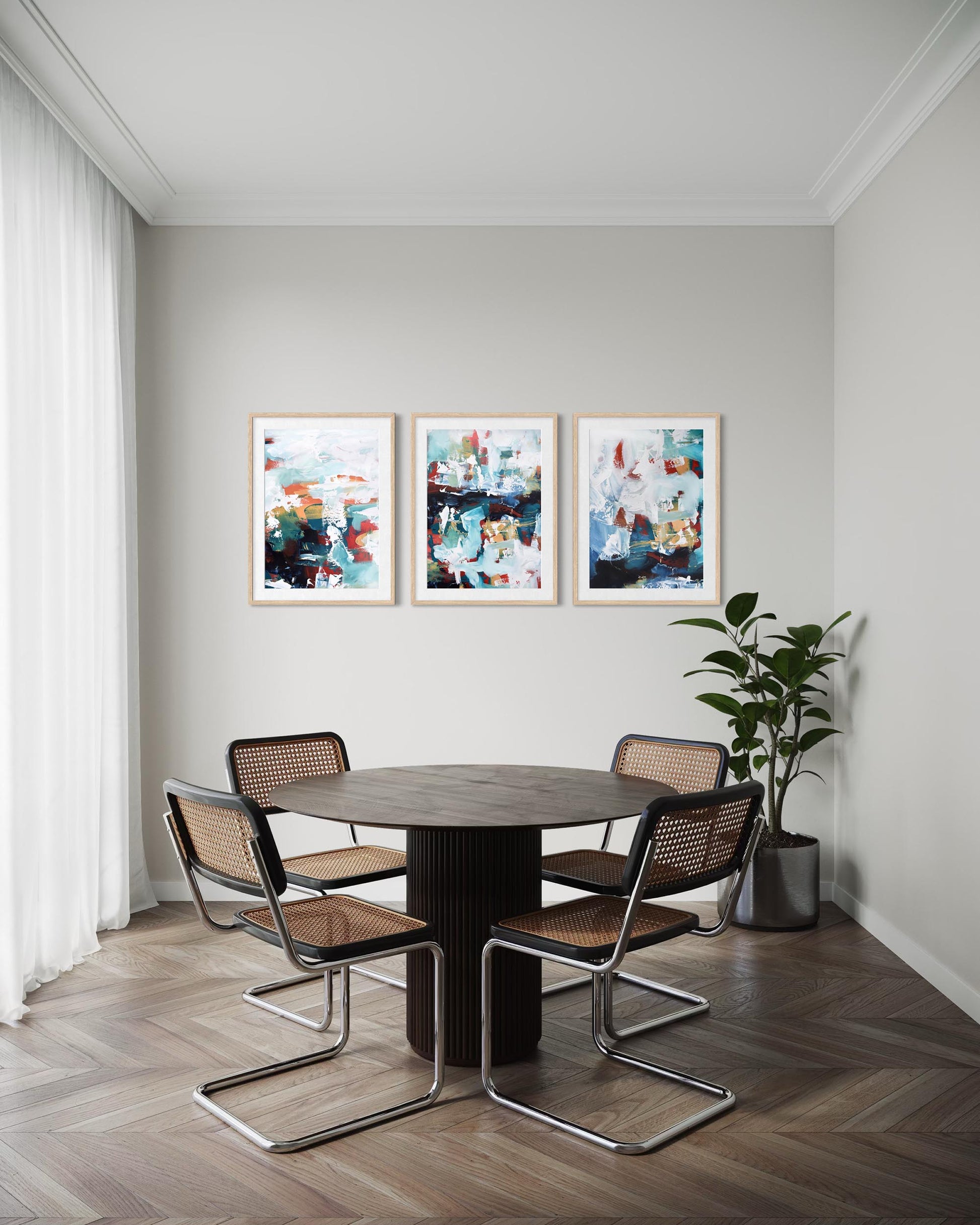 Dining room with a round table and four chairs, featuring abstract art on the wall.