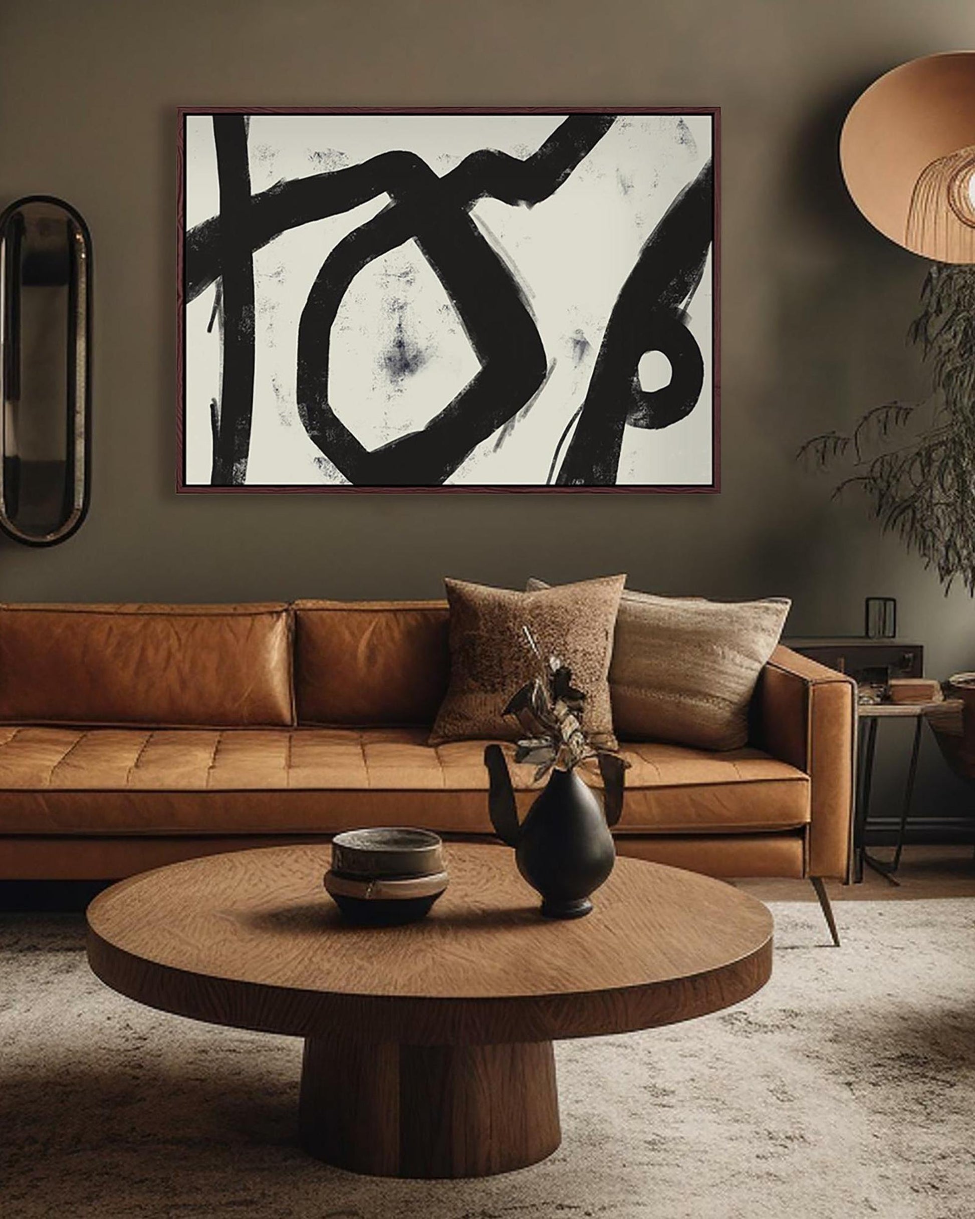 Modern living room with brown leather sofa, abstract art, and wooden coffee table.