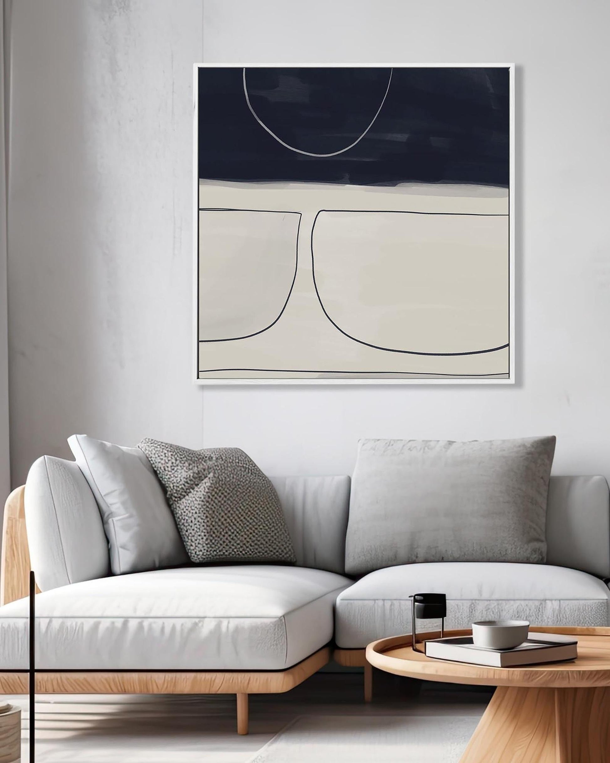 Modern living room with a gray sofa, abstract art on the wall, and a wooden coffee table.