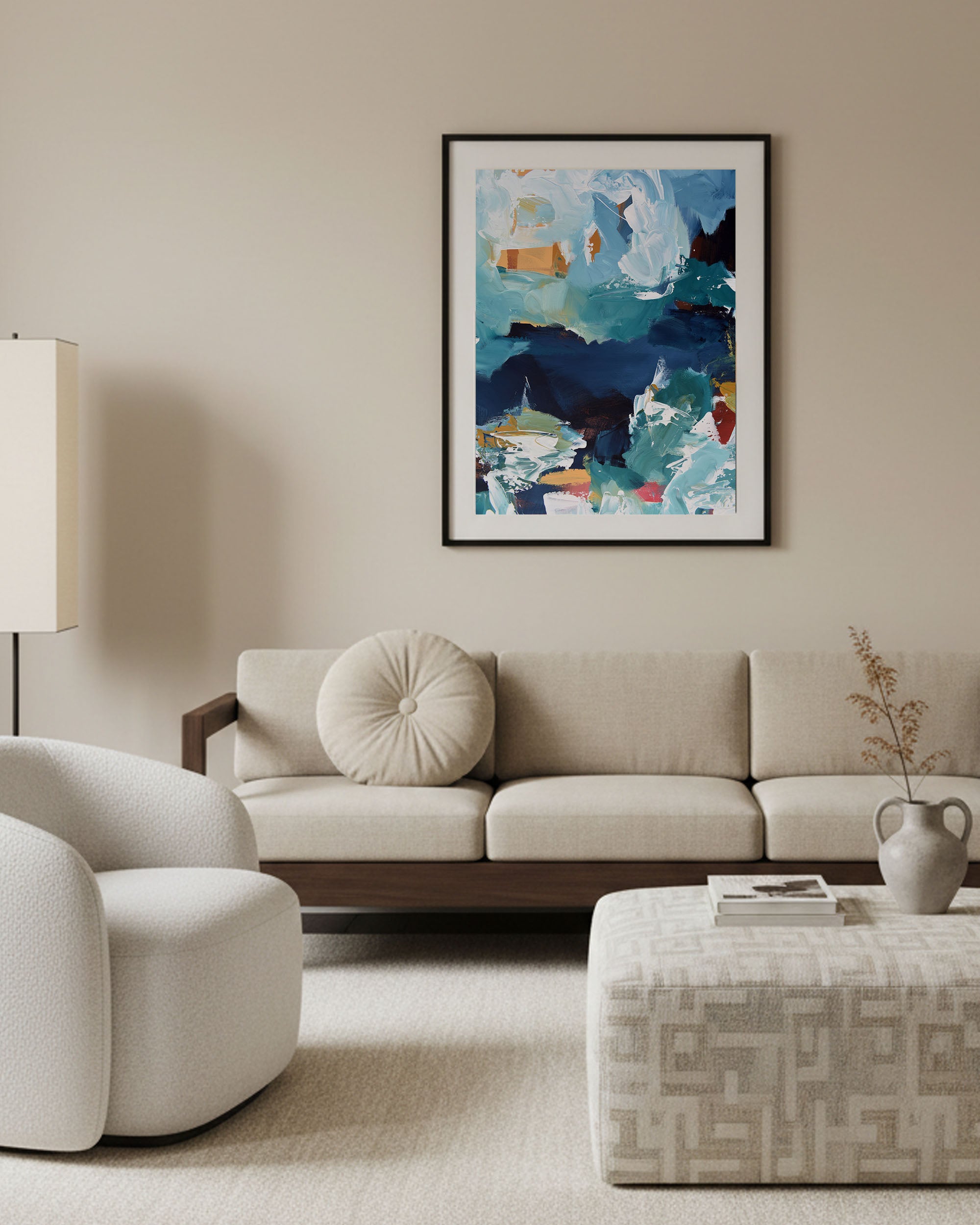 Modern living room with a beige sofa, armchair, and abstract painting on the wall.