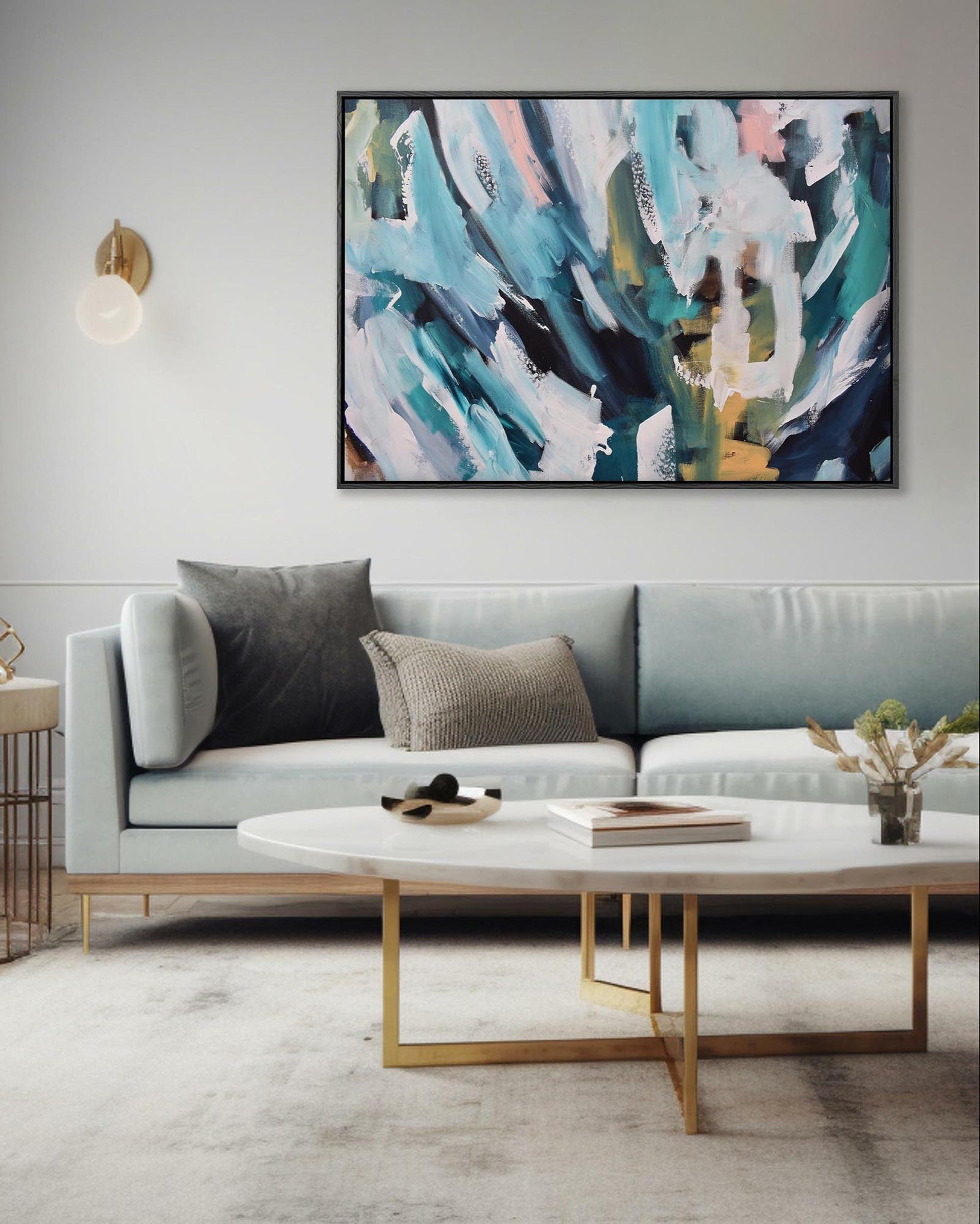 Modern living room with a gray sofa, abstract painting, and decorative items.