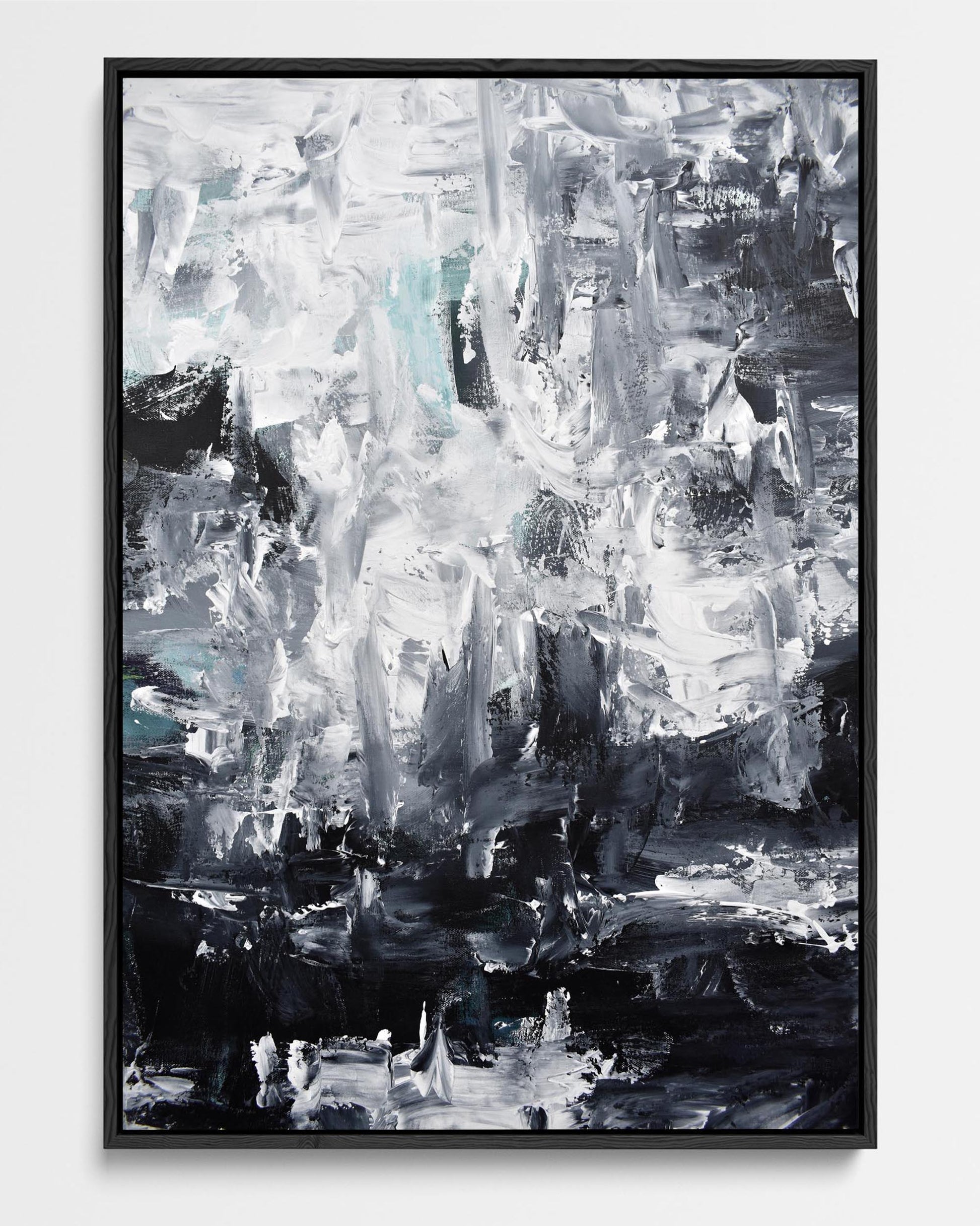A framed canvas print featuring an abstract design with black, grey, and white colors, displayed against a plain background.