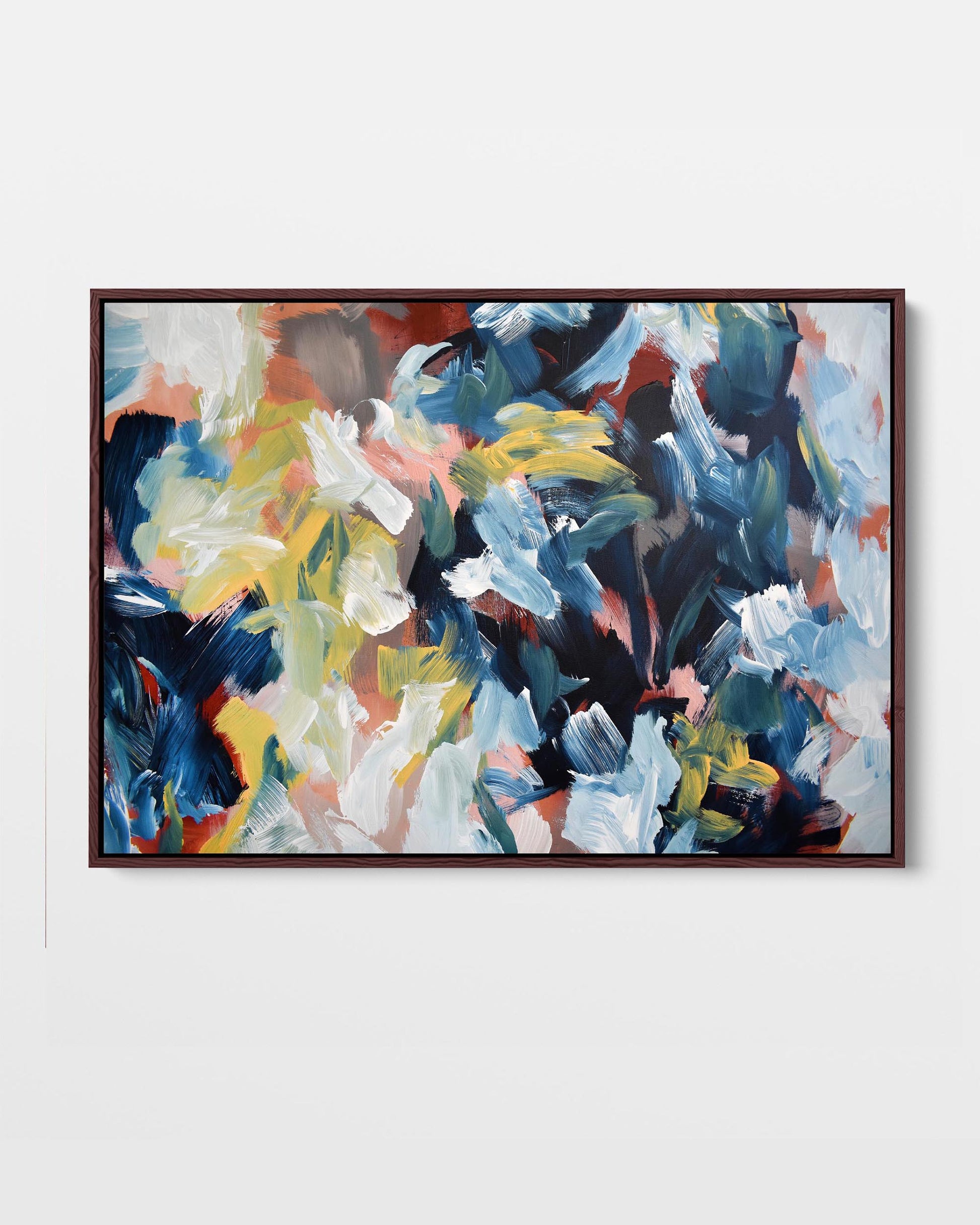 A framed canvas print with an abstract design featuring modern blue, yellow, green, and red tones.