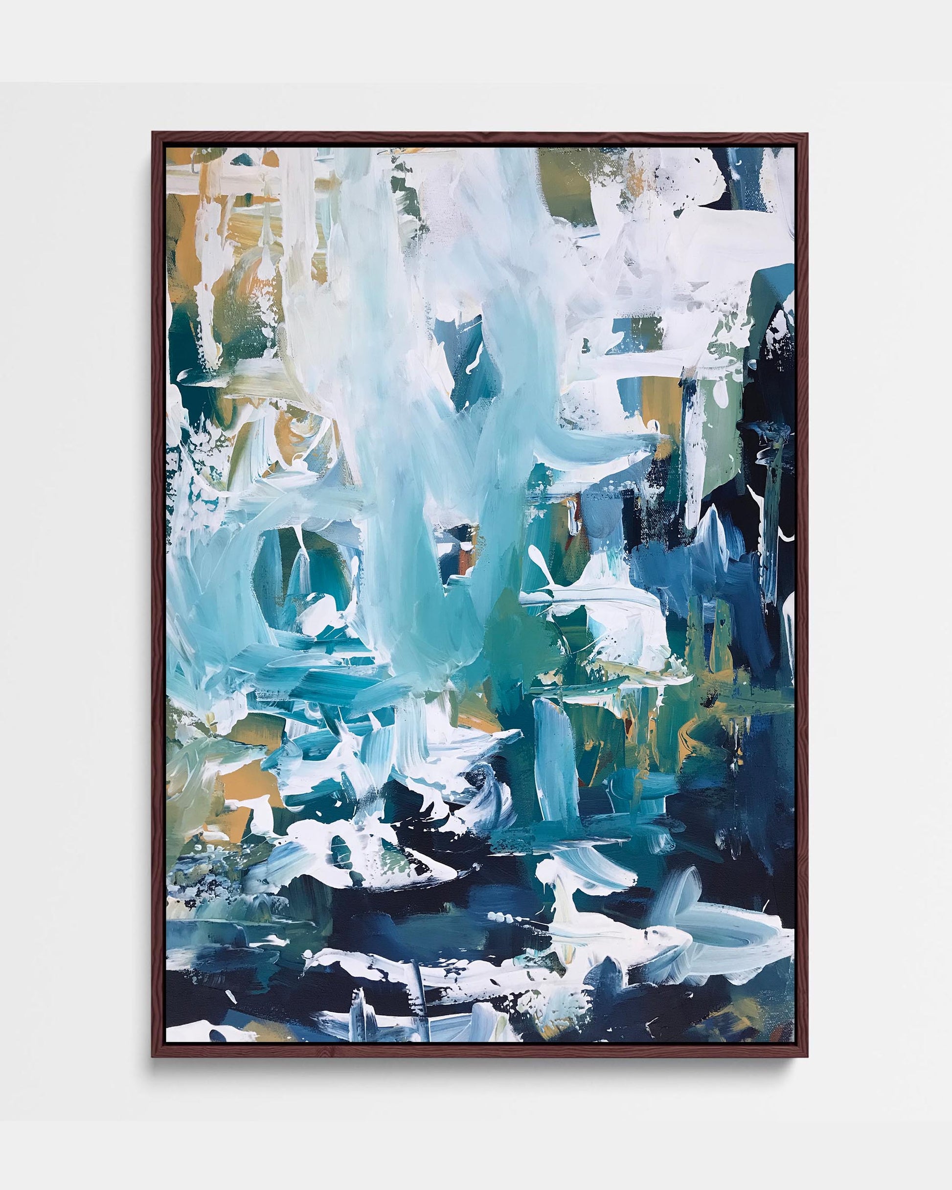 A framed canvas featuring an abstract blue artwork with white and green accents, presented in a brown frame.