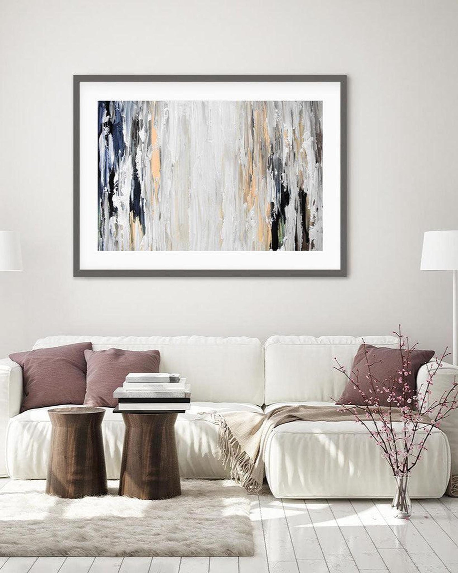 Living room with a white sofa, abstract art on the wall, and decorative elements.