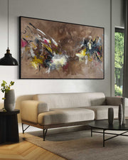 Modern living room with a beige sofa, abstract painting, and decorative items.
