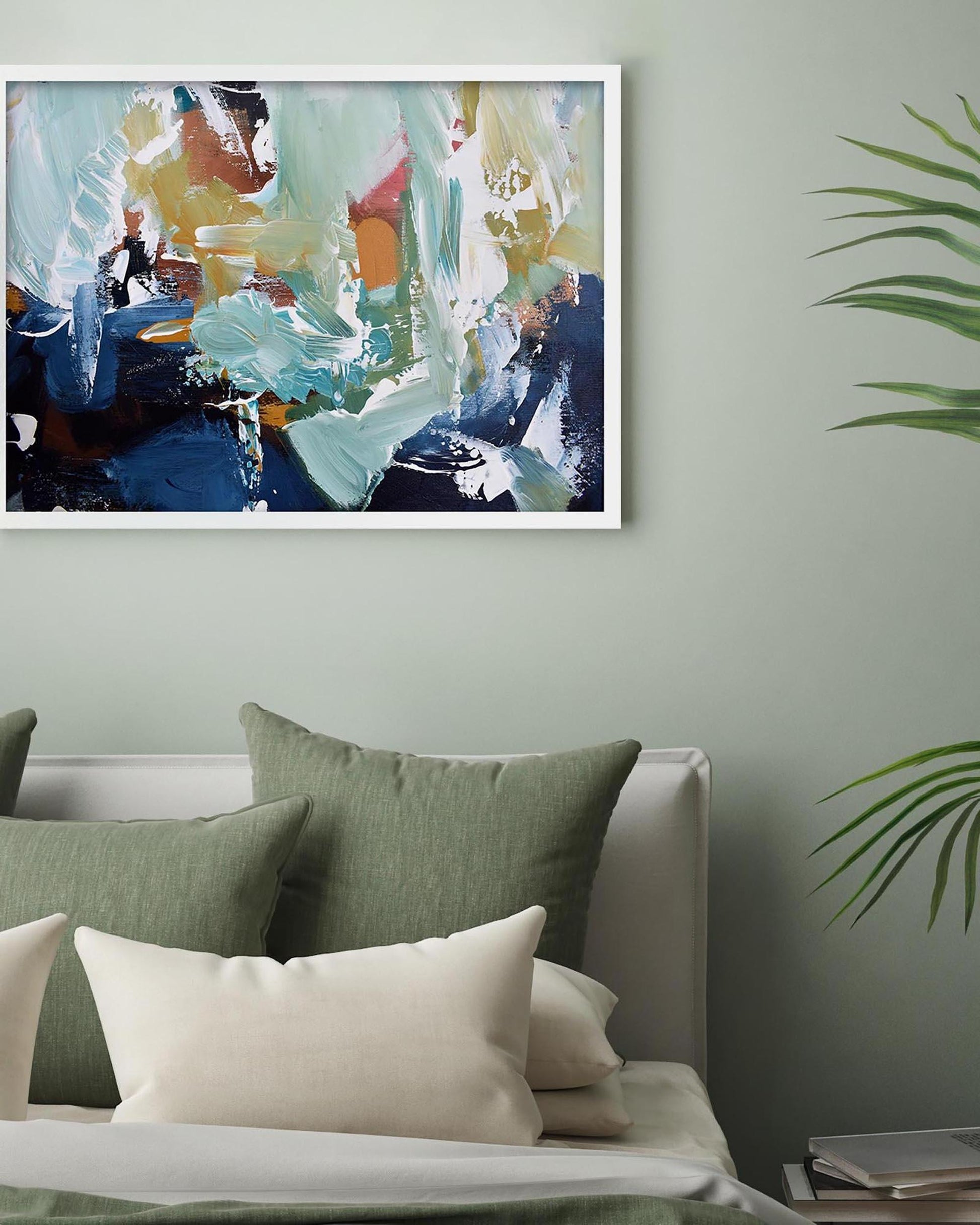 Abstract painting on a wall above a sofa with green and white cushions.