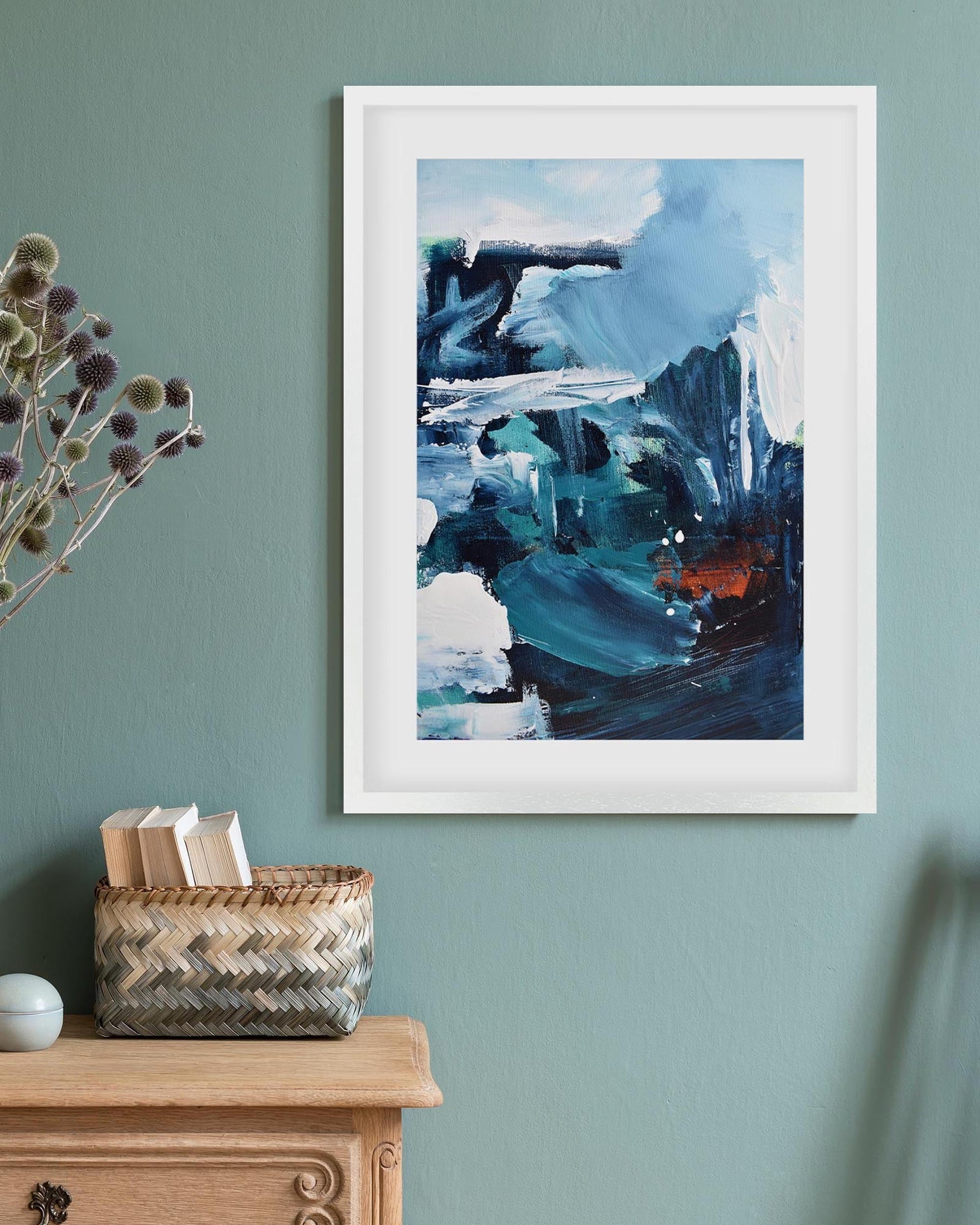 Framed abstract art on a wall with decorative items below