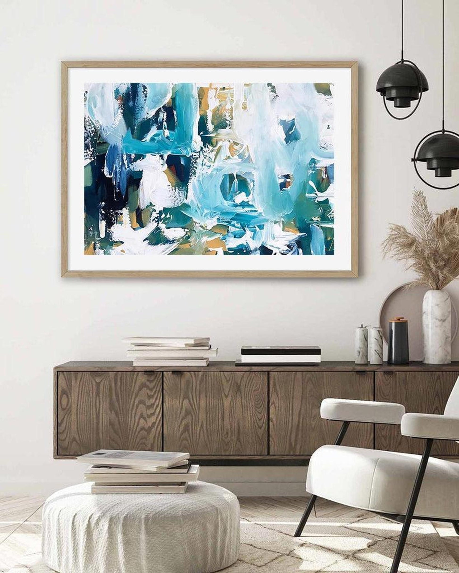 a large framed print hung on a wall above sideboard 