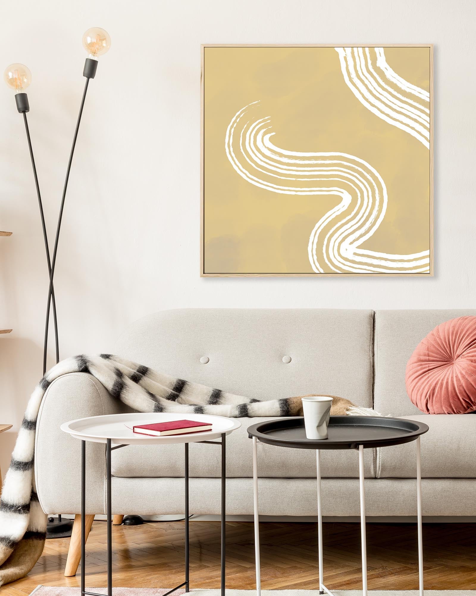 Modern living room with abstract wall art, sofa, and side tables.