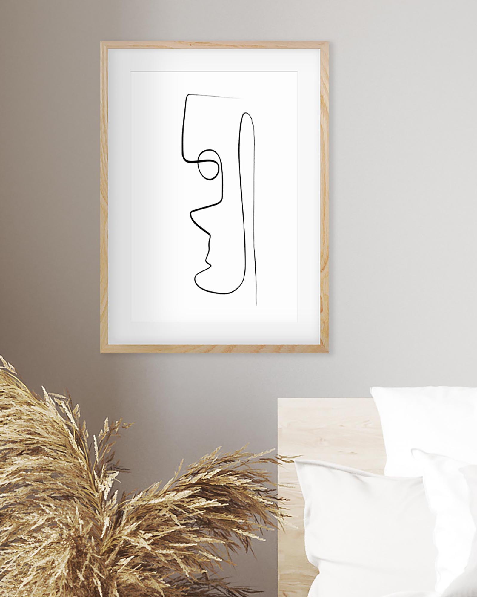 Framed abstract line art of a face on a wall with decorative elements.