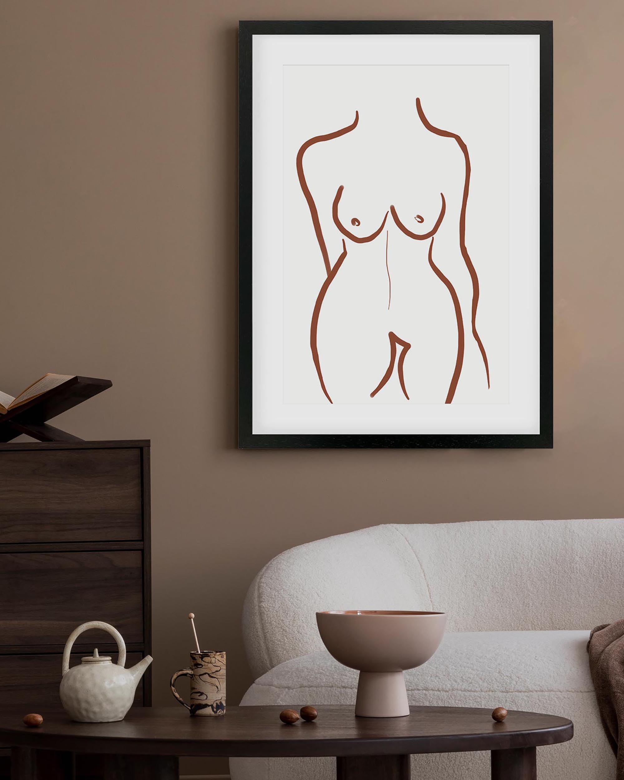 Framed abstract art of a nude figure on a wall above a sofa and coffee table.