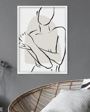 Minimalist line art of a person on a gray wall with a wicker chair and white pillow in the foreground.