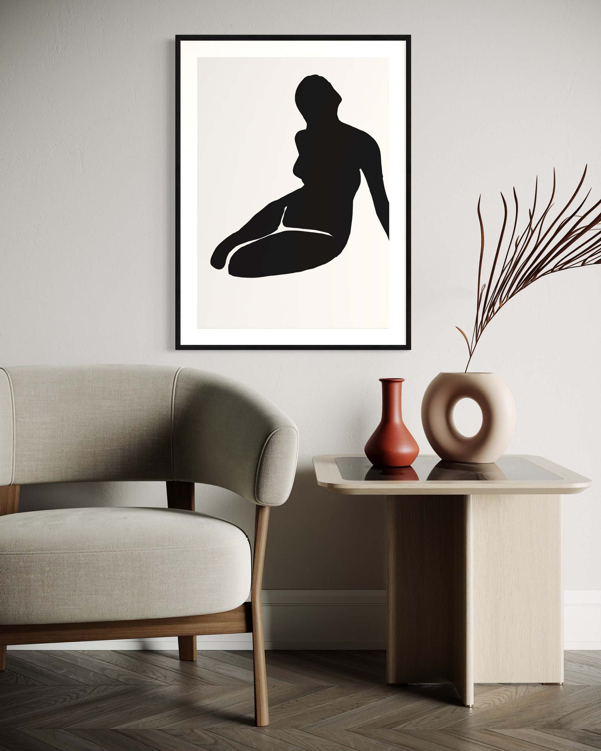 Framed black and white silhouette art print on a wall above a sofa.