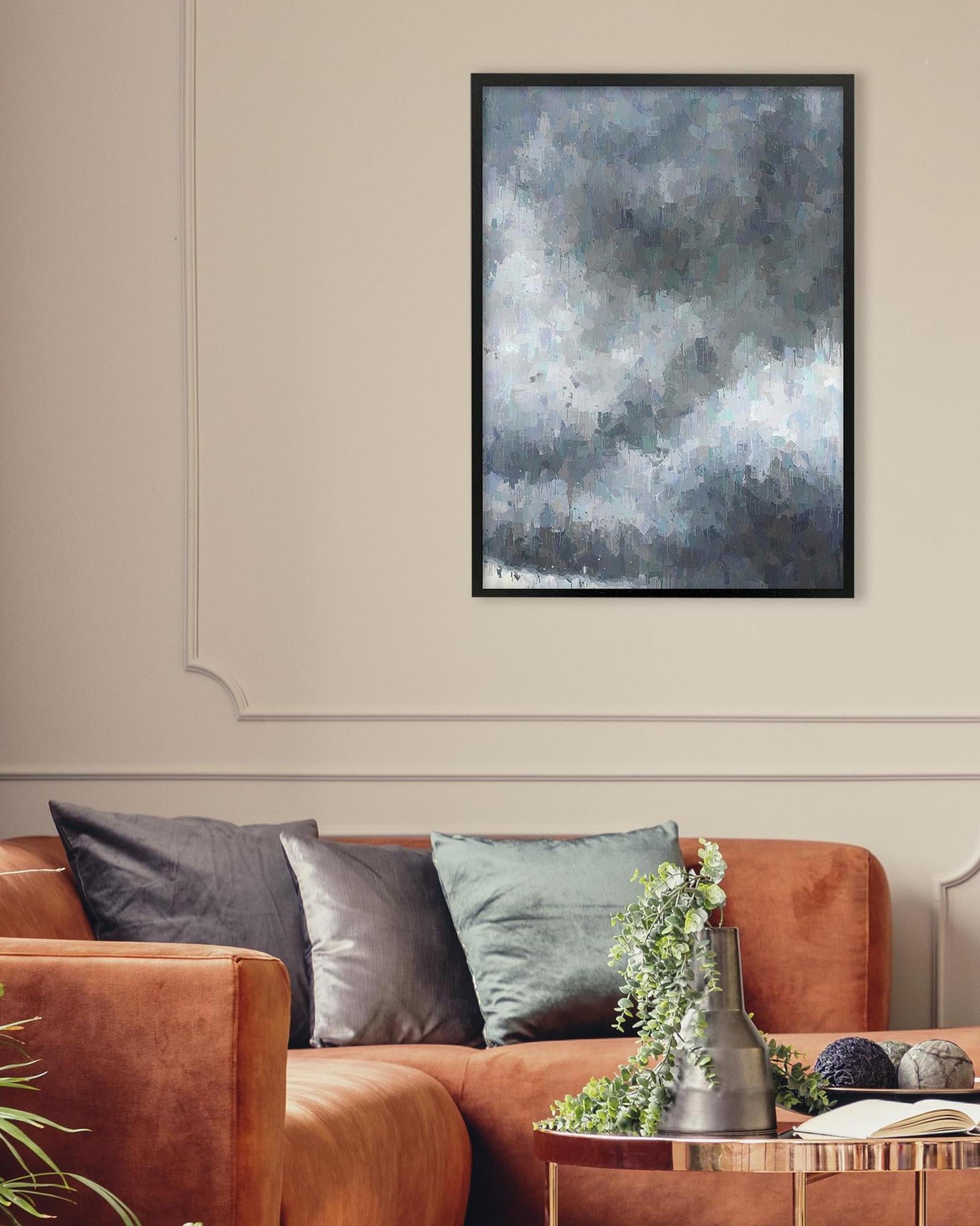 Framed abstract art above a brown sofa with decorative pillows and plants.