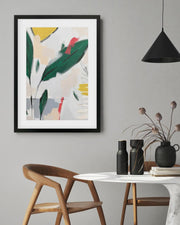 Framed abstract art piece on a wall above a dining table with decor items.