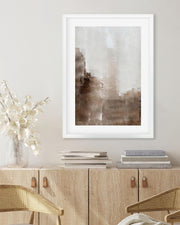 Framed abstract art piece on a wall above a wooden console table with decorative items.