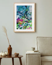 Framed abstract painting on a wall above a table with decorative items.