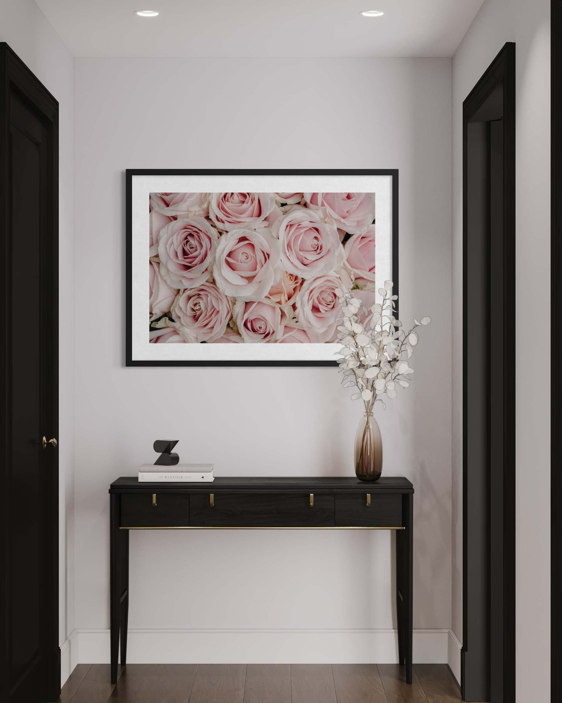 Framed floral artwork above a console table in a hallway.
