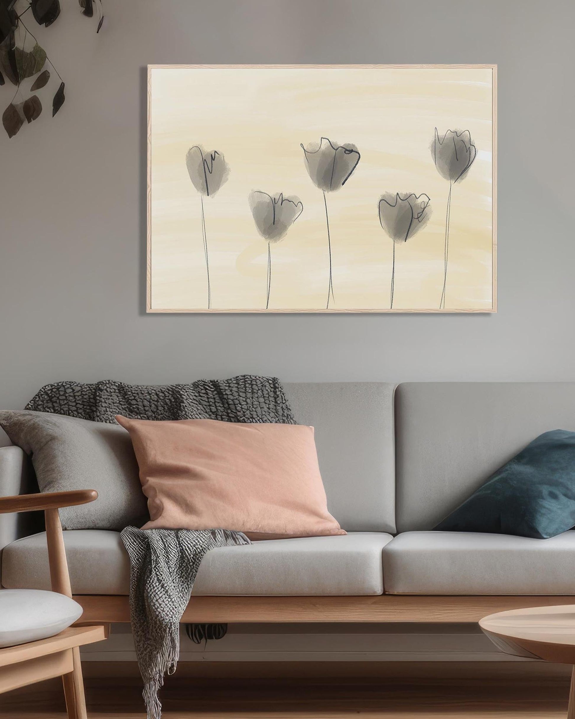 Gray sofa with decorative pillows and a painting of flowers on the wall in a living room.