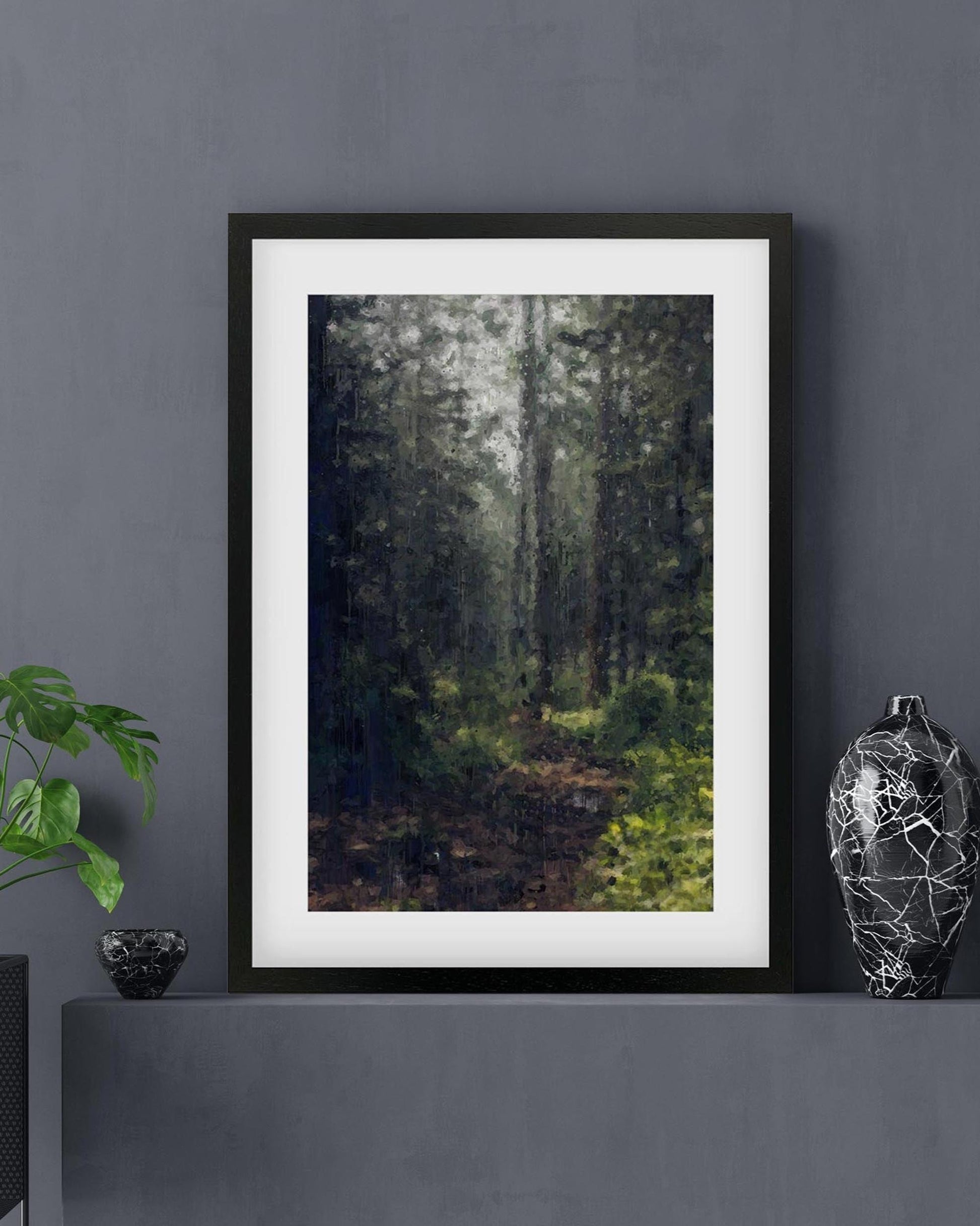 Framed artwork of a forest scene on a dark gray wall with decorative items.