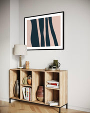 Wooden sideboard with decorative items against a wall with a framed abstract art piece.
