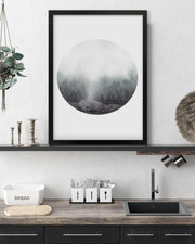 Framed circular artwork above a kitchen counter with utensils and a bread bin.