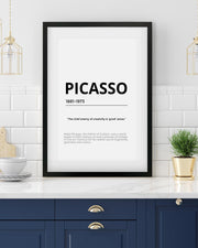 Framed Picasso quote on a wall in a modern kitchen setting