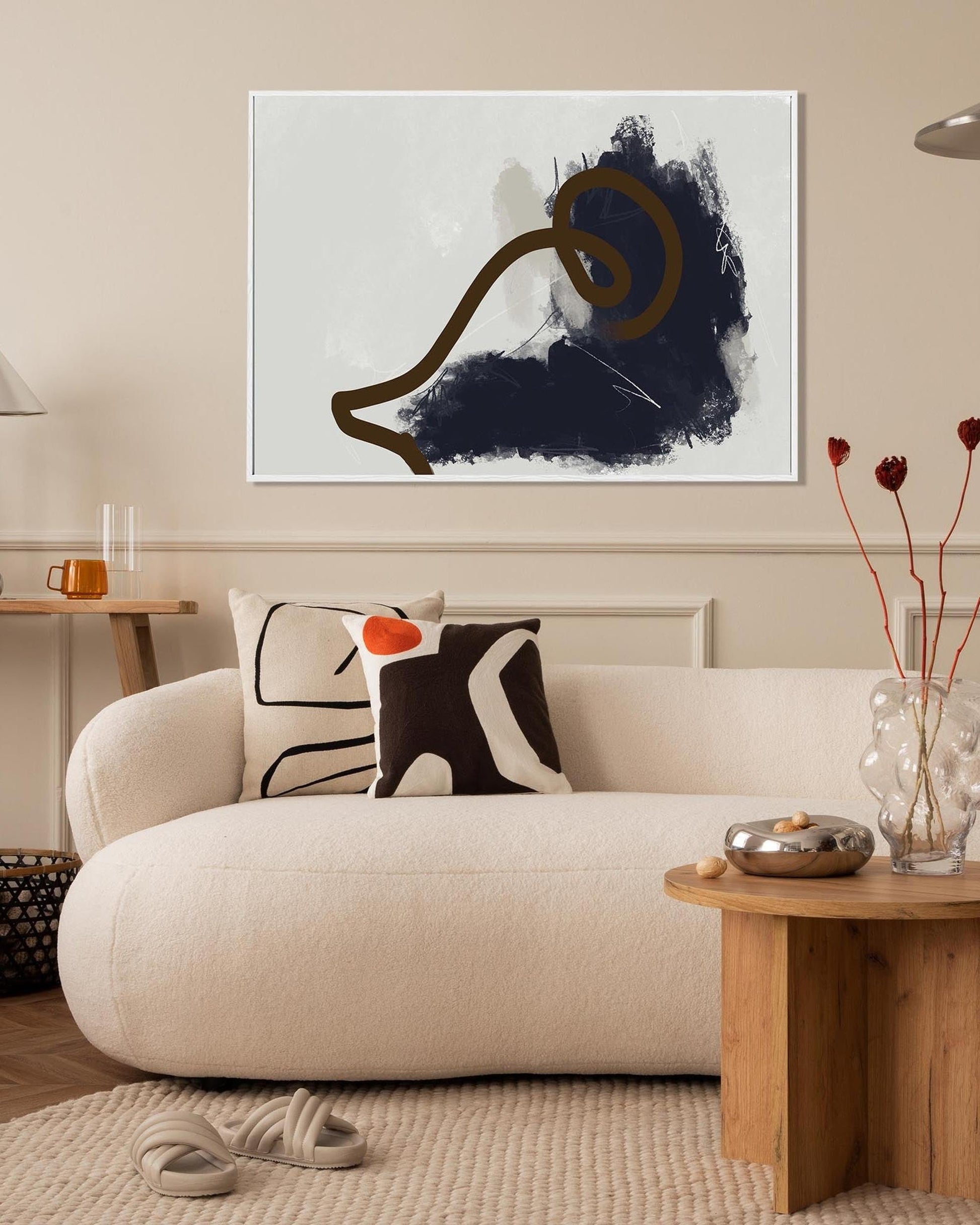 Modern living room with a beige sofa, abstract art, and decorative elements.