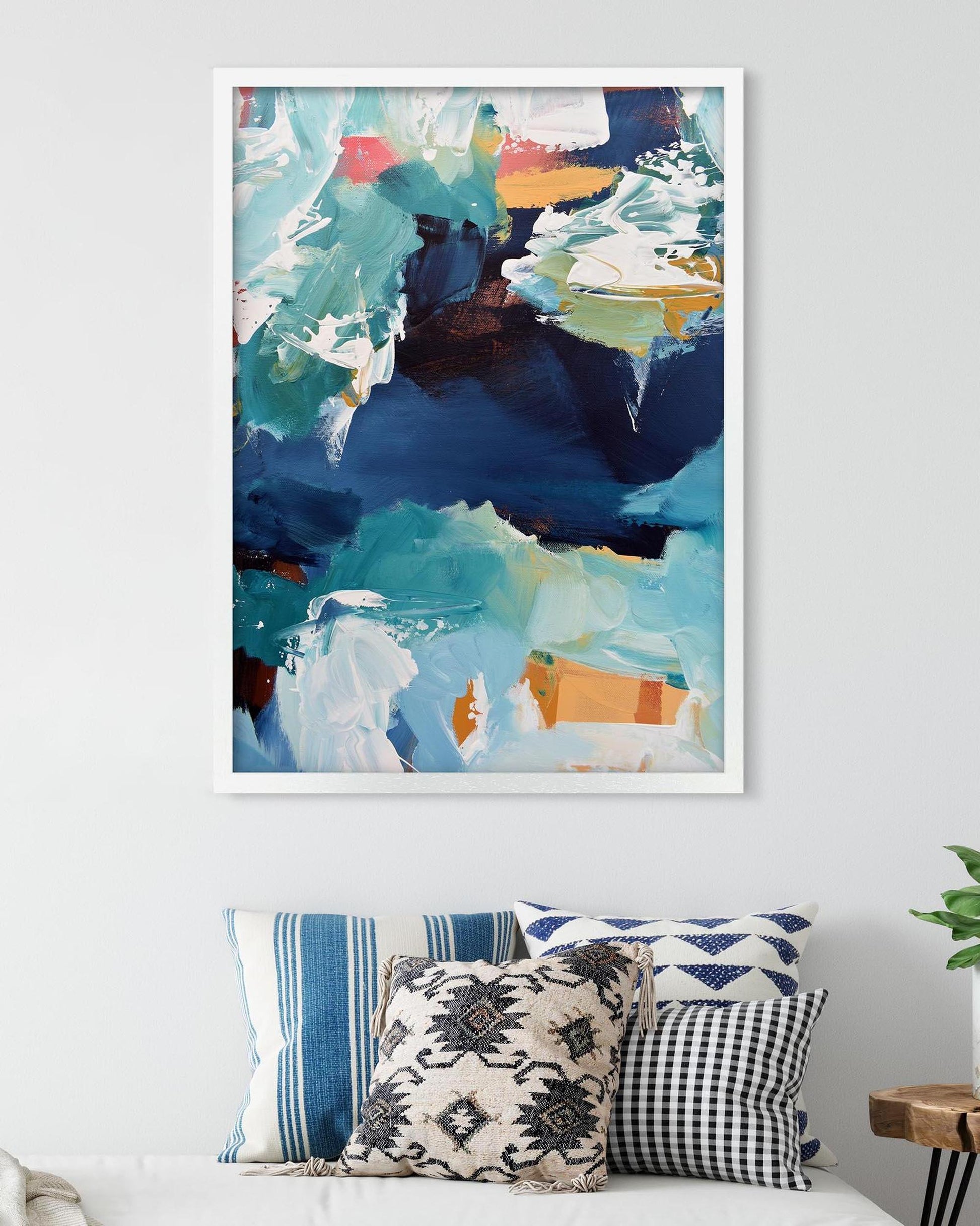 Abstract art print on a wall with decorative pillows below