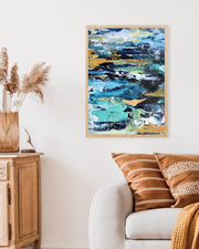 Abstract painting on a wall above a sofa with decorative pillows and a vase.