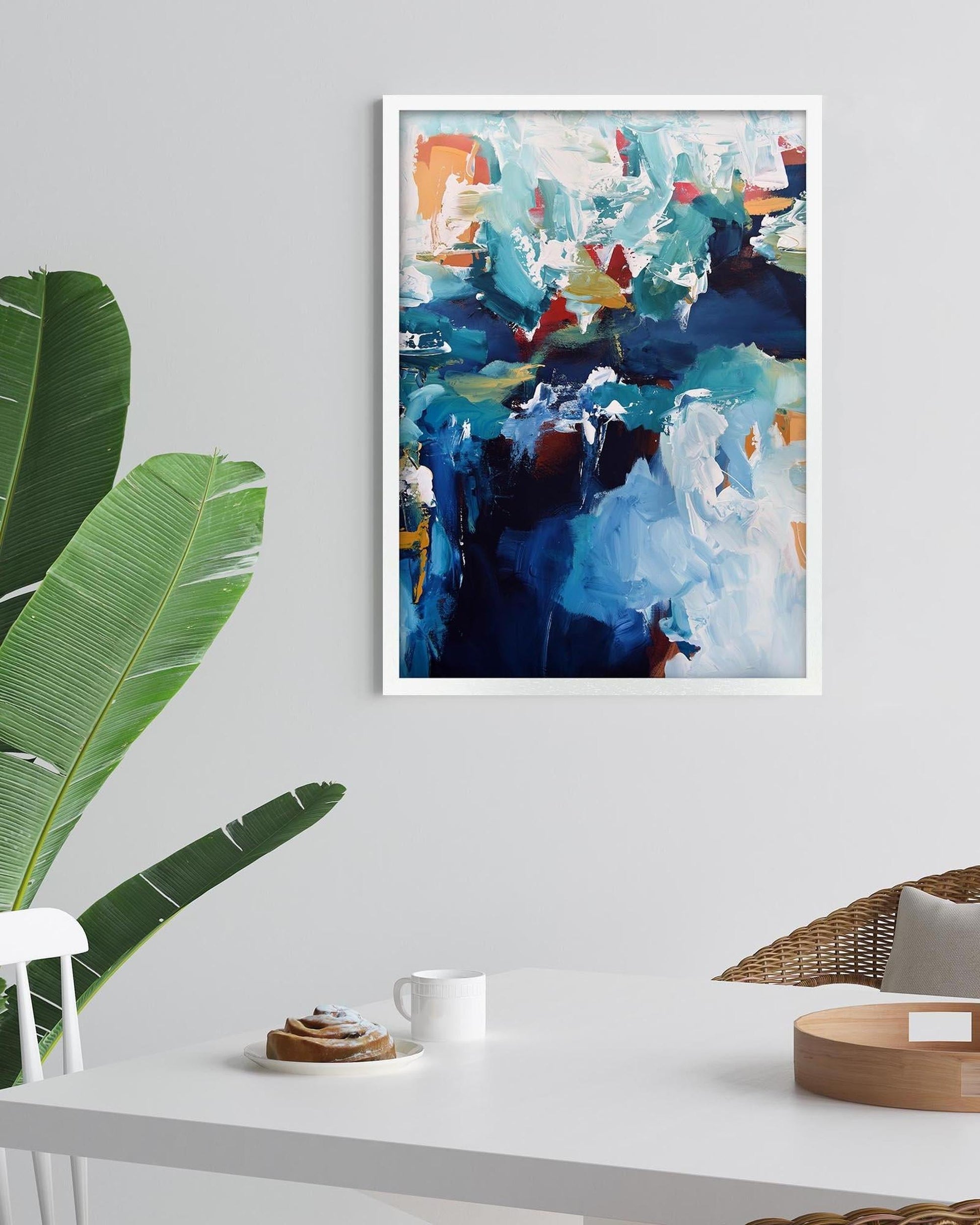 Abstract painting on a wall with a table and plant in the foreground
