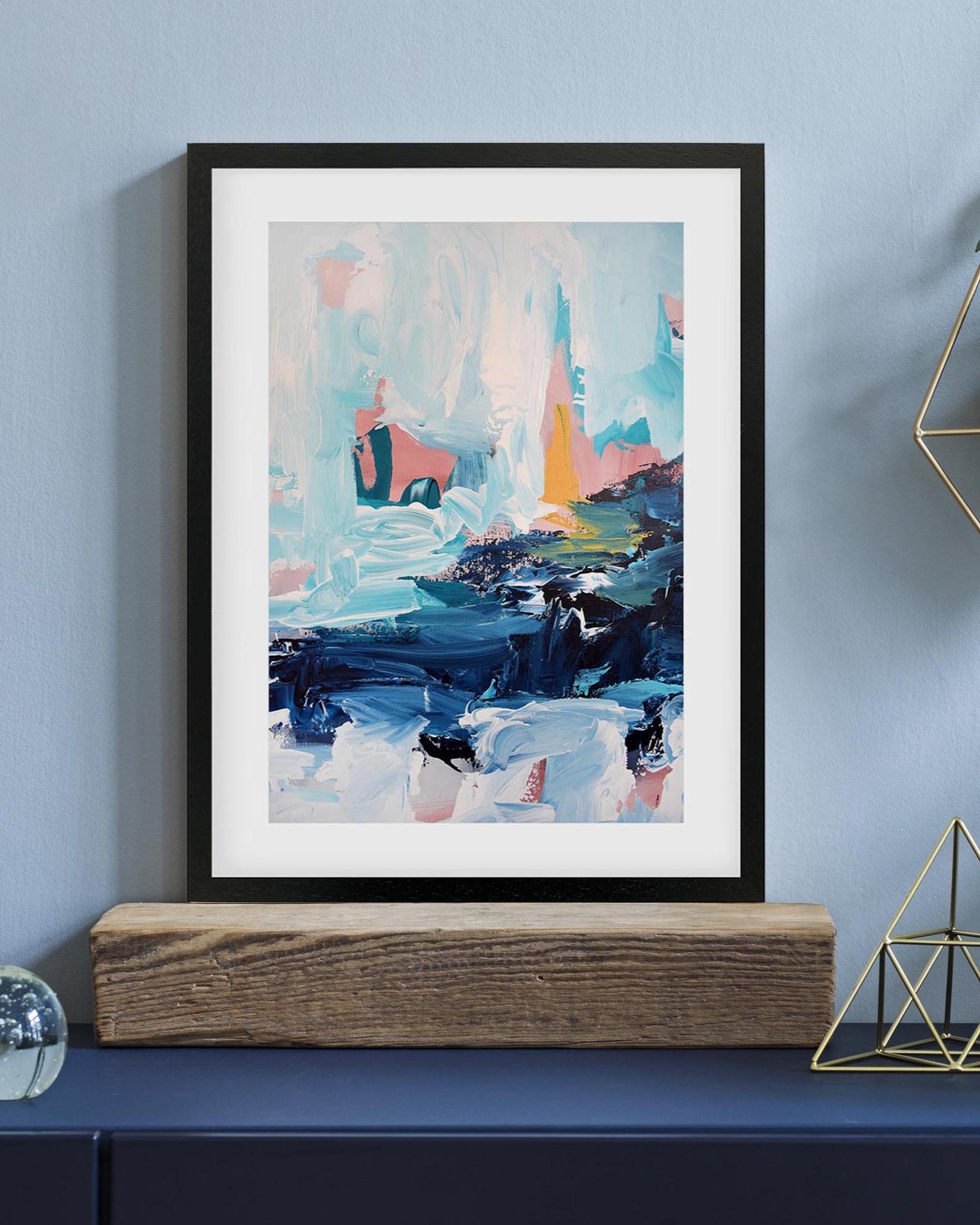 Framed abstract painting on a wall with decorative elements below