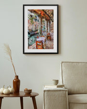 Framed abstract painting on a wall above a table with decorative items.