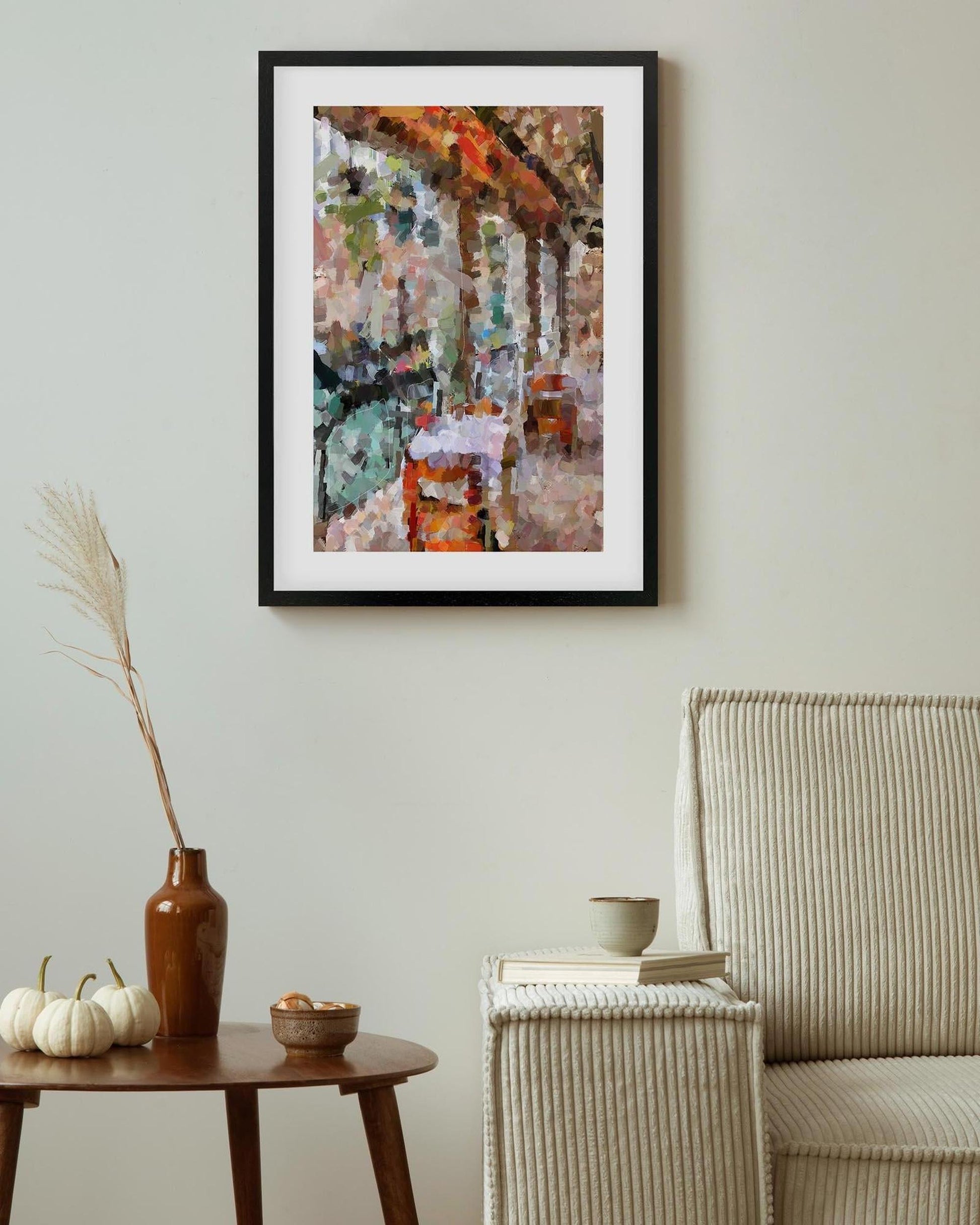 Framed abstract painting on a wall above a table with decorative items.