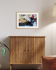 Wooden cabinet with a framed abstract painting above it on a wall.