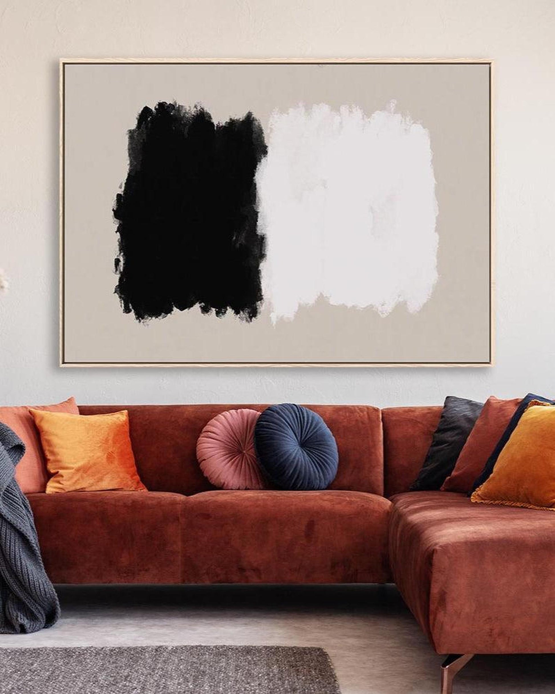 Modern living room with a brown sectional sofa and abstract art on the wall.