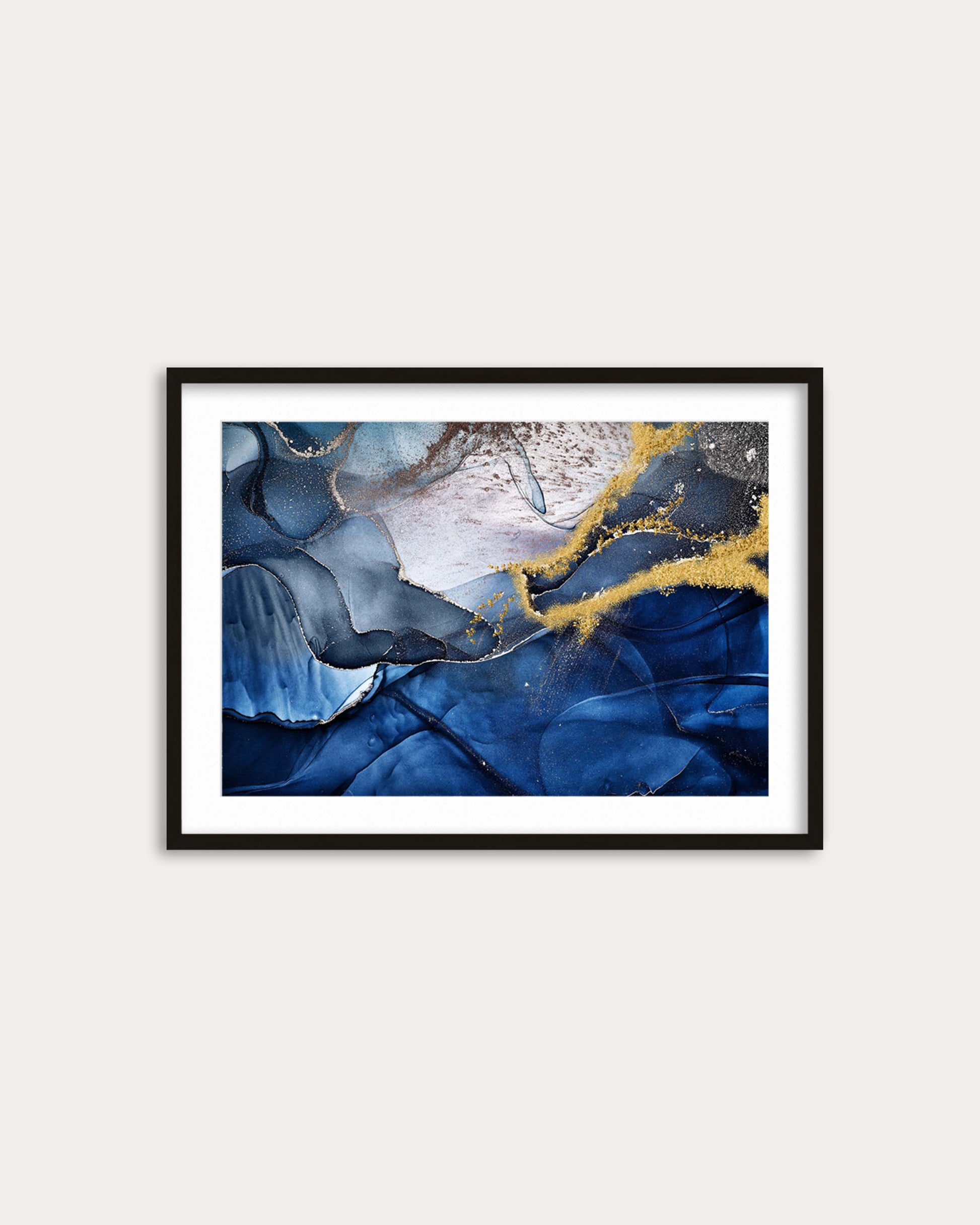 Framed abstract art print with blue and gold colors on a white wall