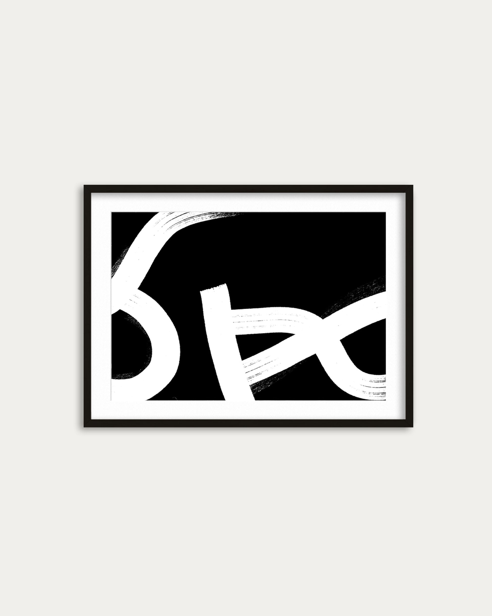 Framed abstract art with black and white design on a light gray wall