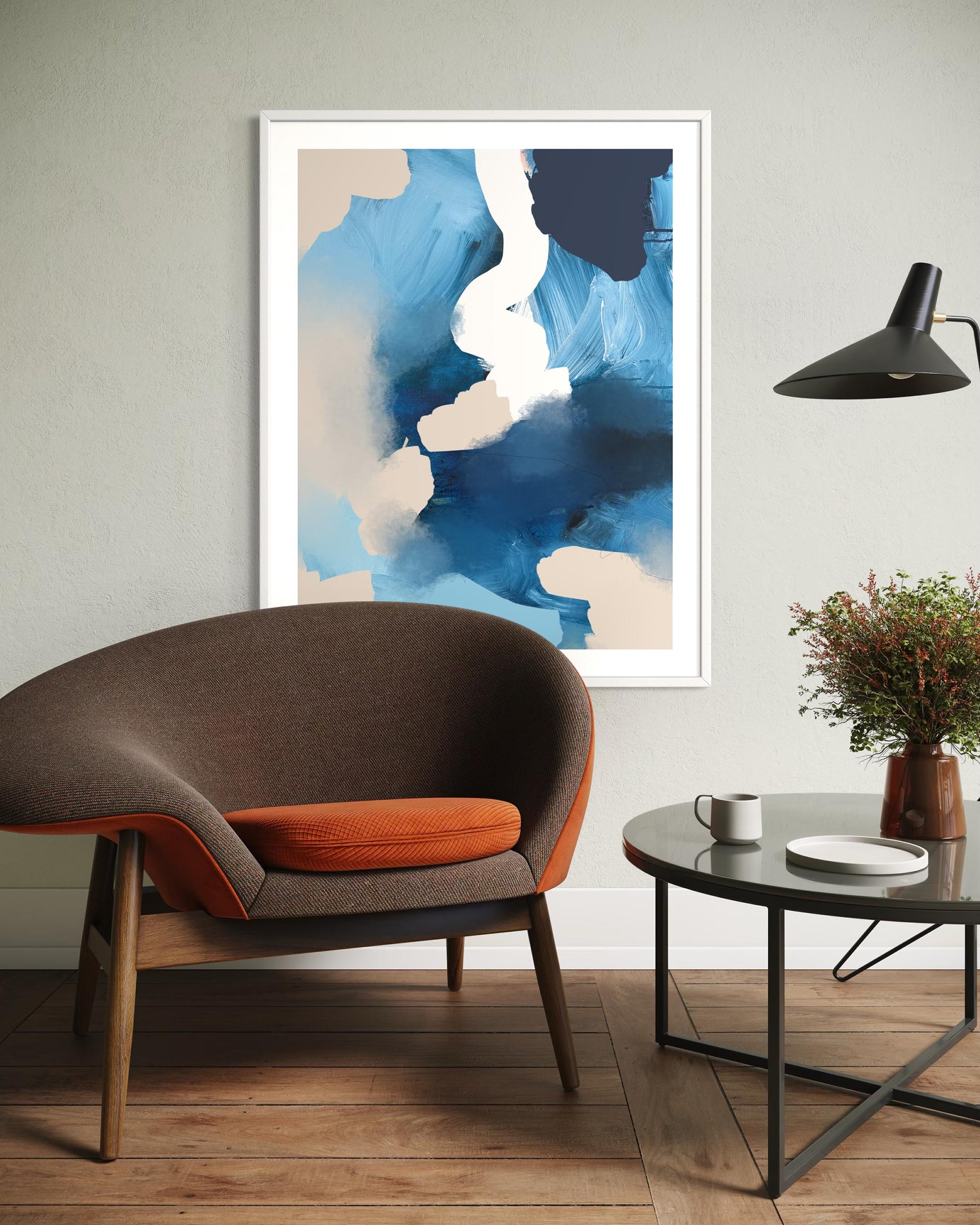 Modern interior with a brown chair, round table, and abstract art on the wall.