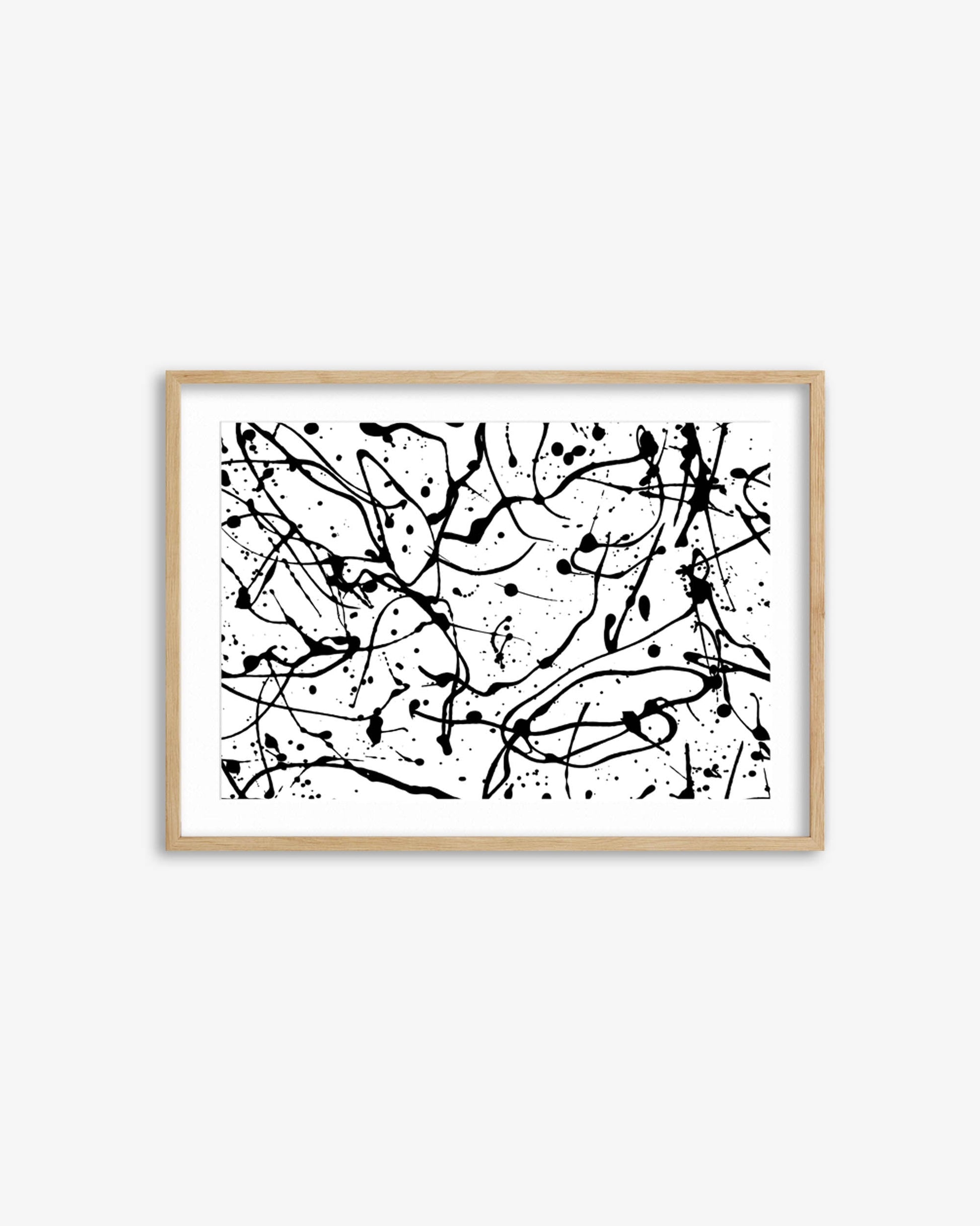 Framed abstract artwork with black splashes on a white background