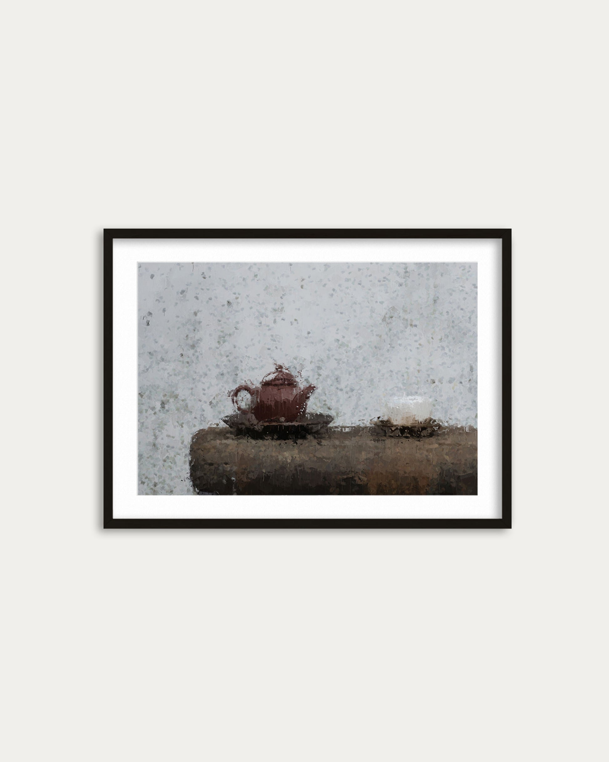 Framed photograph of a teapot on a stone surface with a textured wall background