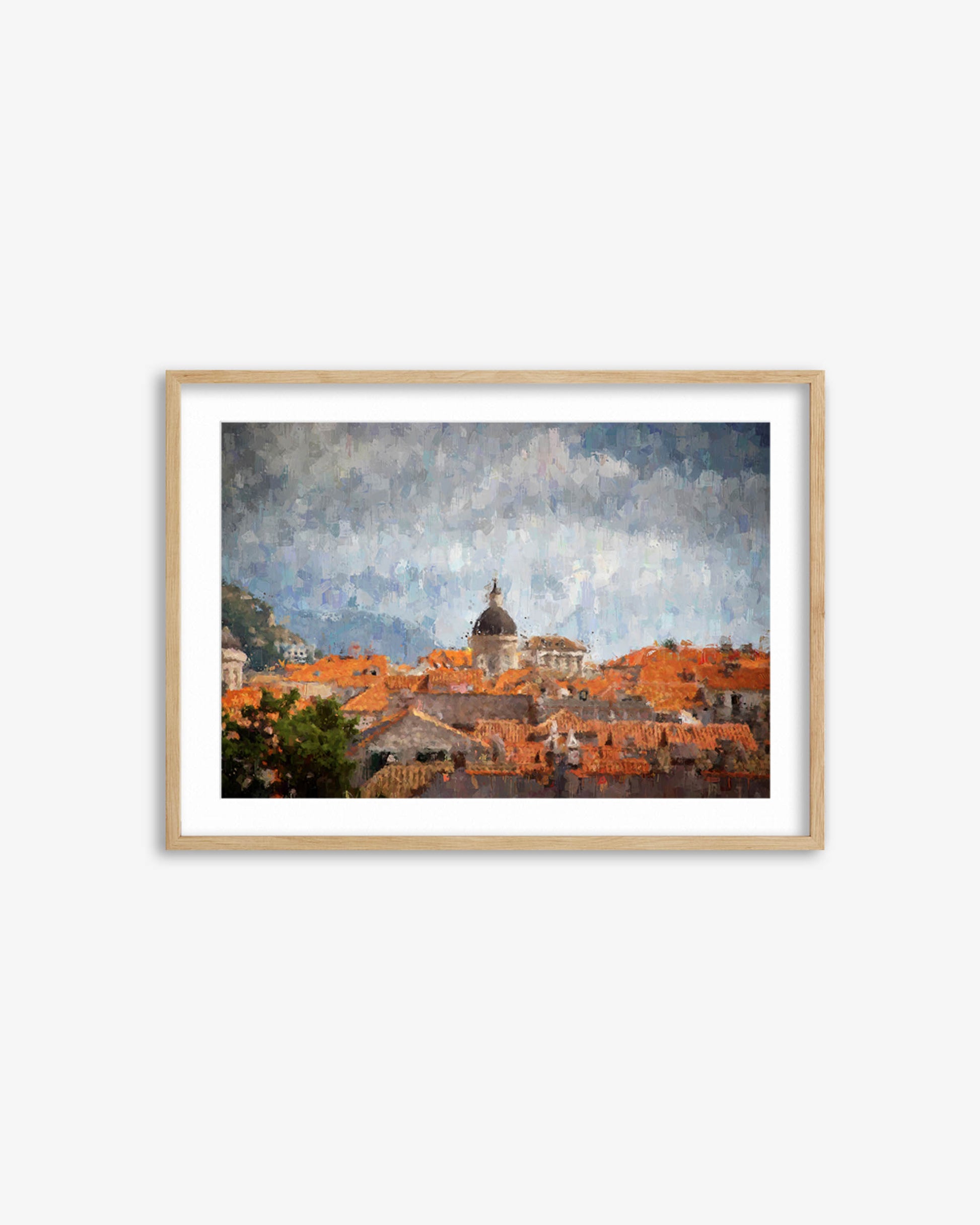 Framed artwork of a cityscape with orange rooftops and a dome, on a white background.