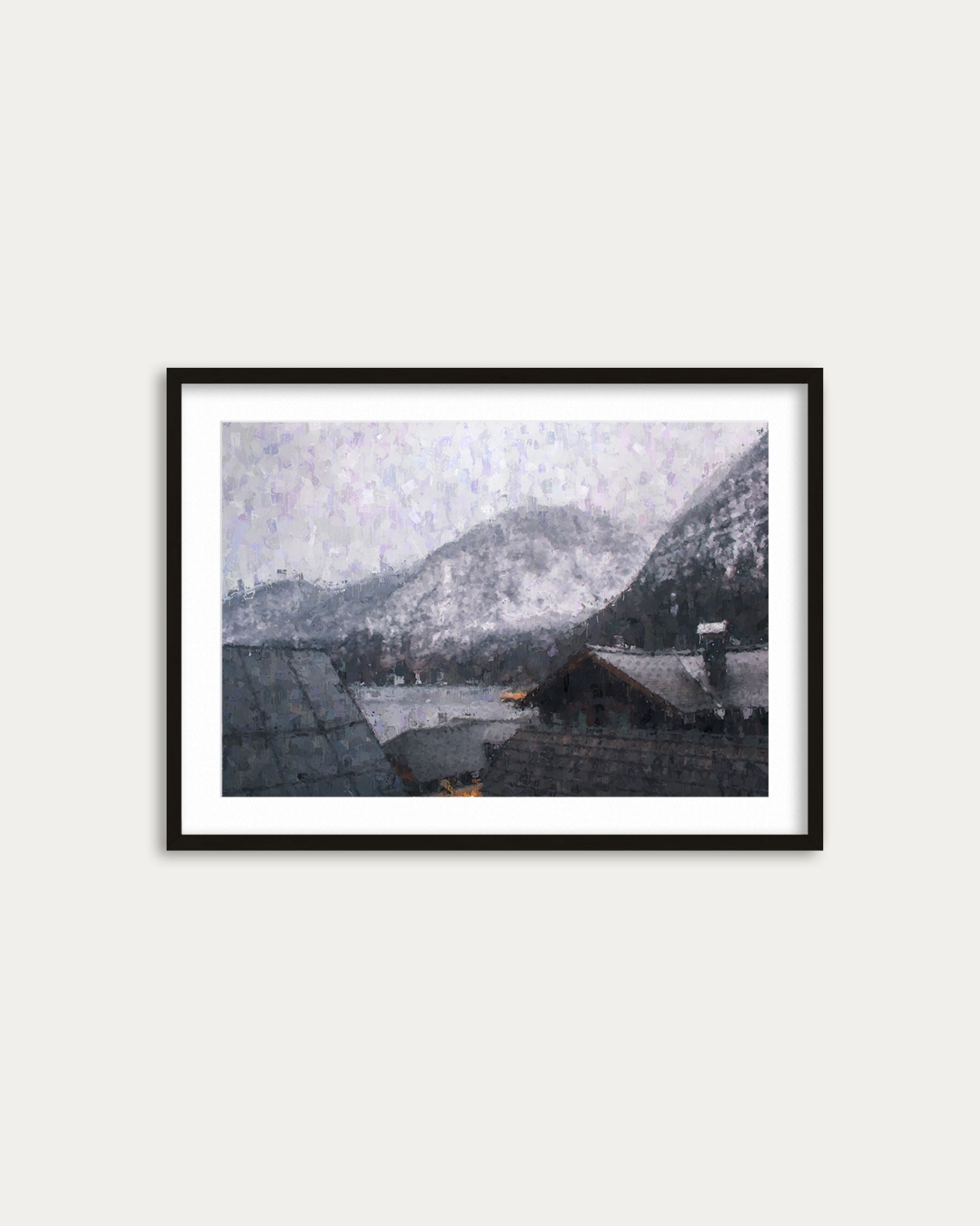 Framed artwork of a snowy mountain landscape with houses, on a white wall.