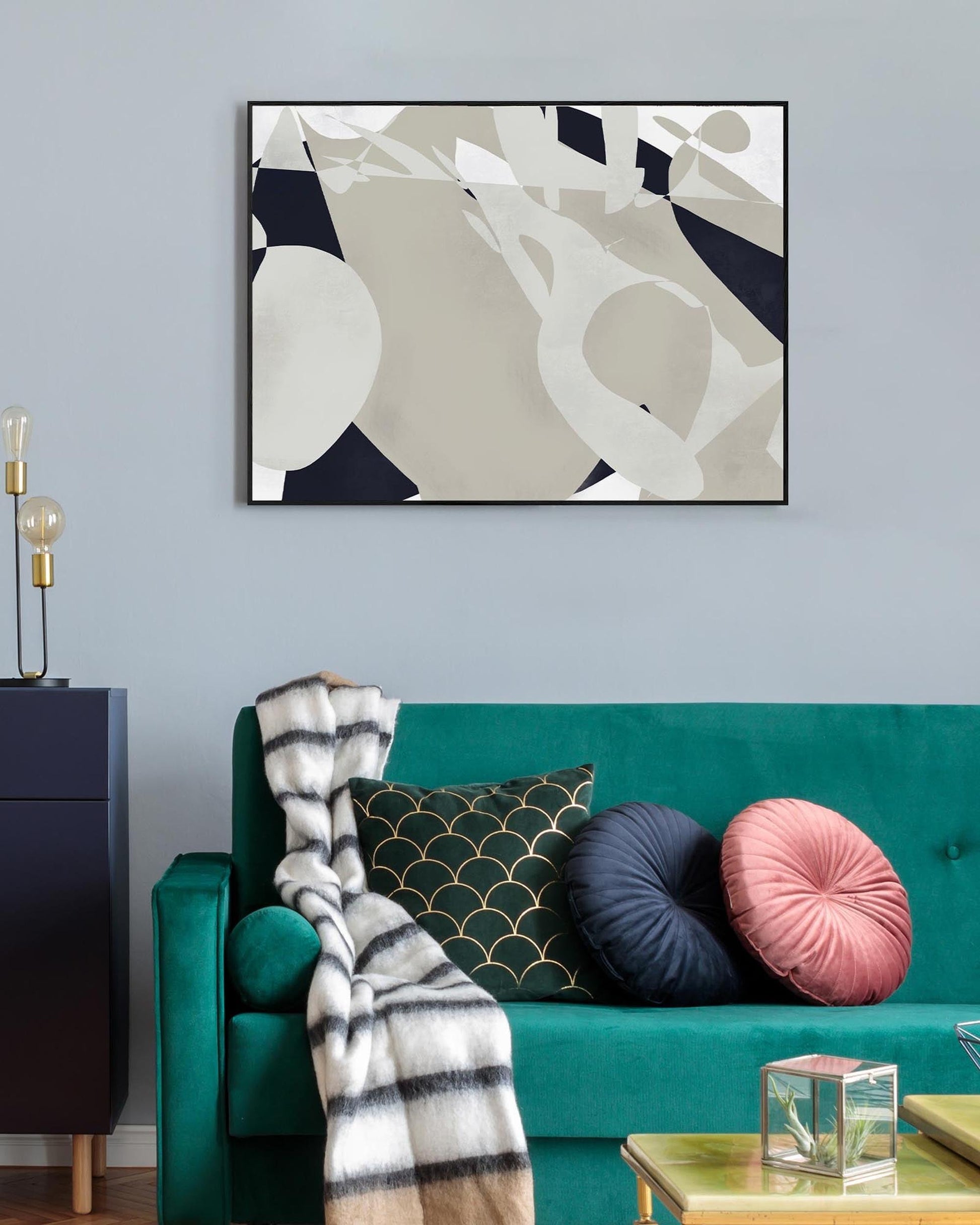 Living room with a teal sofa, abstract art on the wall, and decorative pillows.
