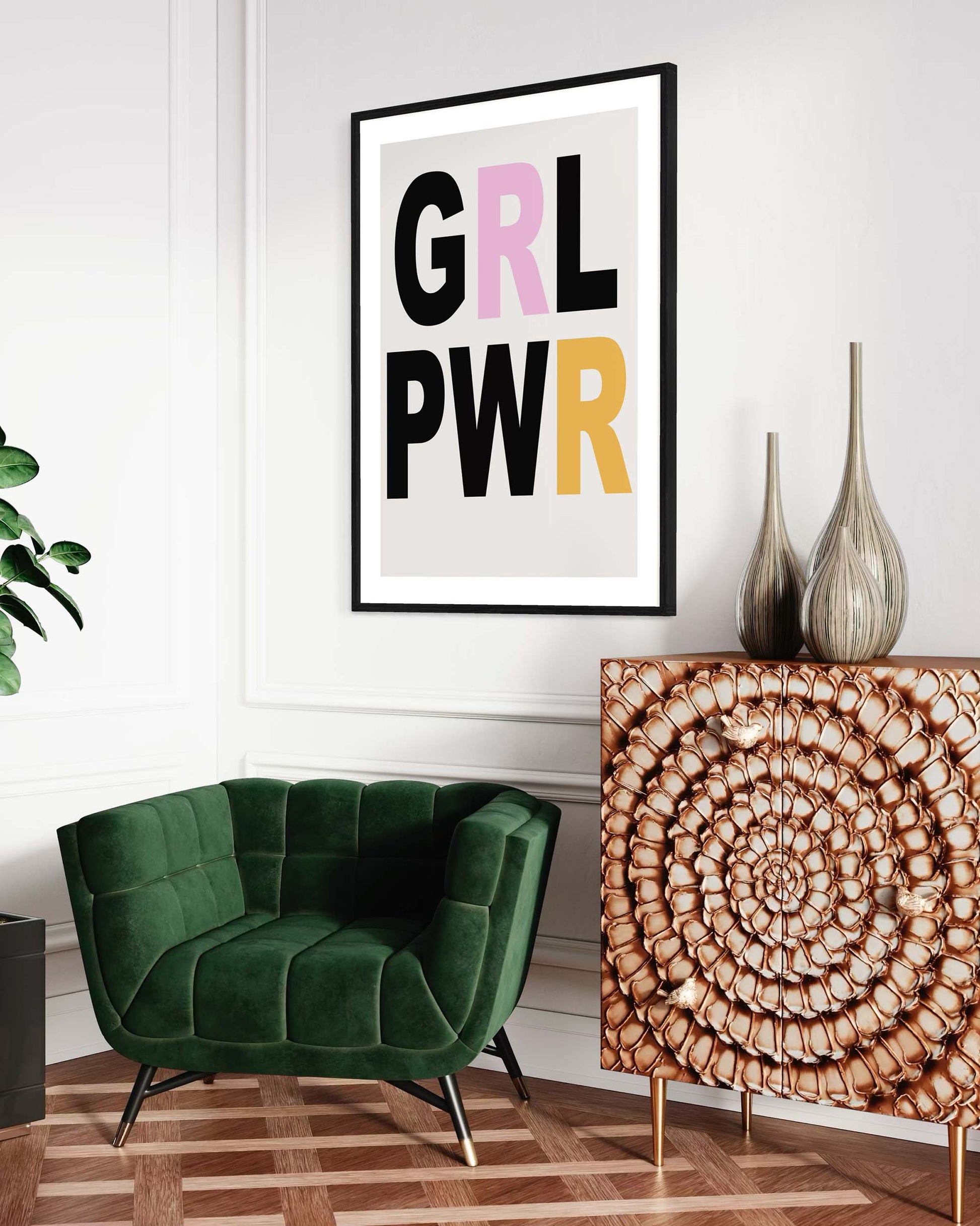 Modern interior with a green armchair, decorative cabinet, and framed 'GIRL PWR' poster.