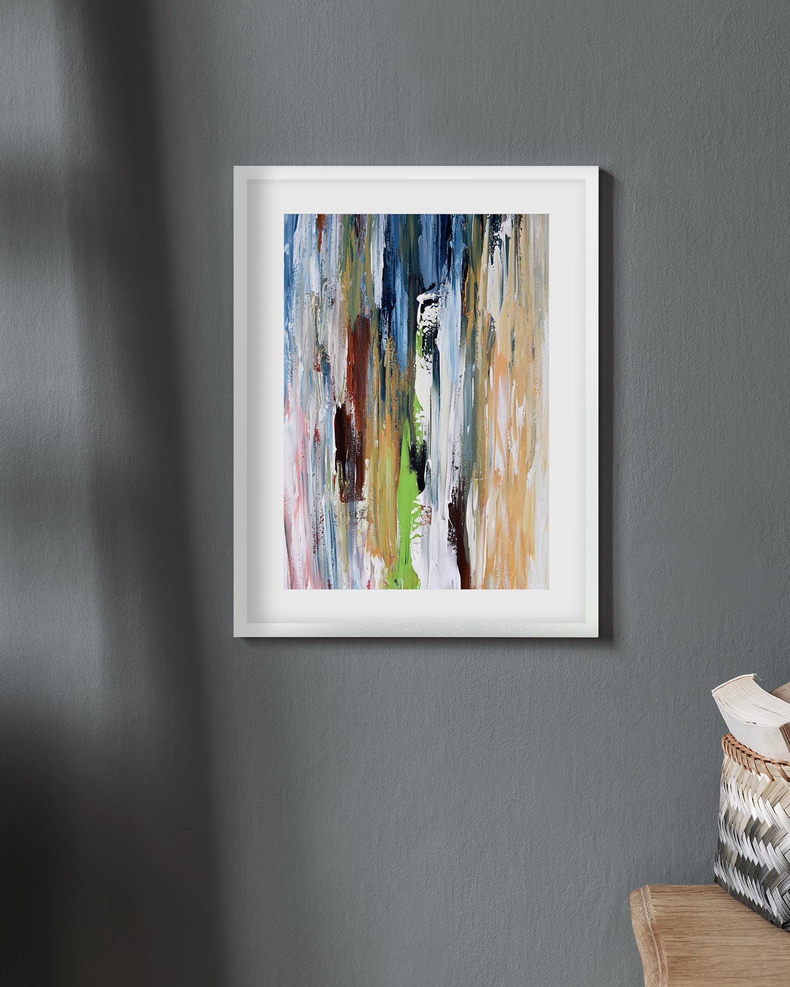 Framed abstract painting on a gray wall with a wooden ladder and basket in the corner.