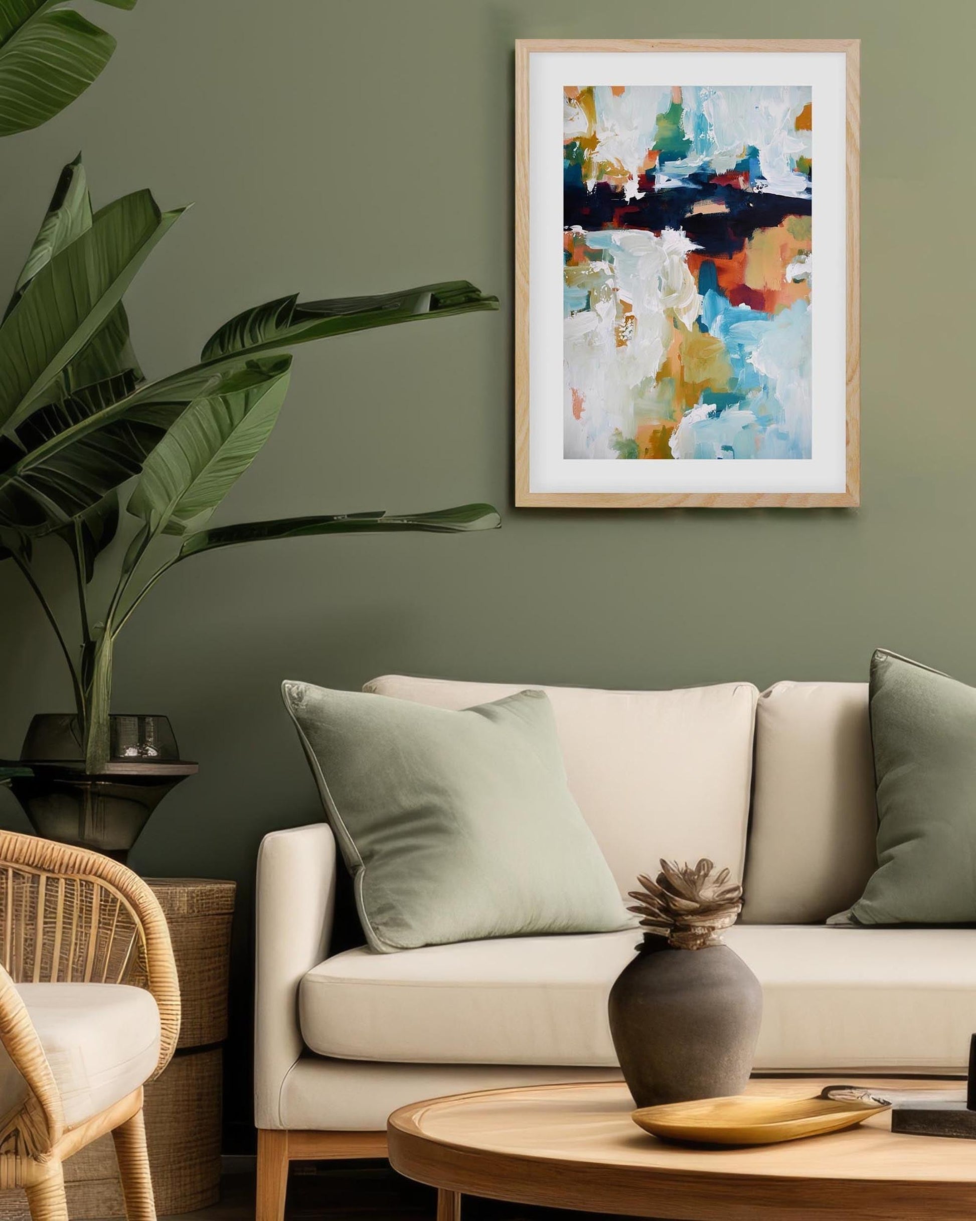 Living room with a beige sofa, wicker chair, and abstract art on the wall.