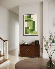 Modern interior with abstract green artwork on a wall above a wooden cabinet.